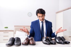 Man Deciding Between Pairs of Shoes